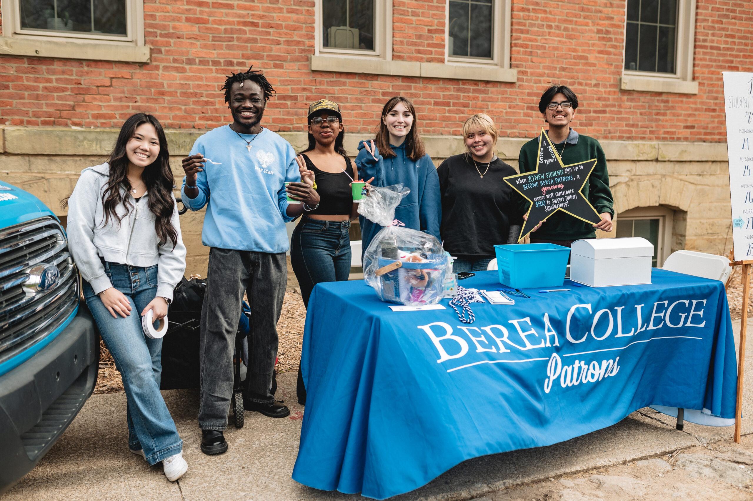 Students smile during an event in front of the Berea Patrons table. From left to right: Kimberly, Kamuskay, Sani, Sydney, Daniela, Hasel